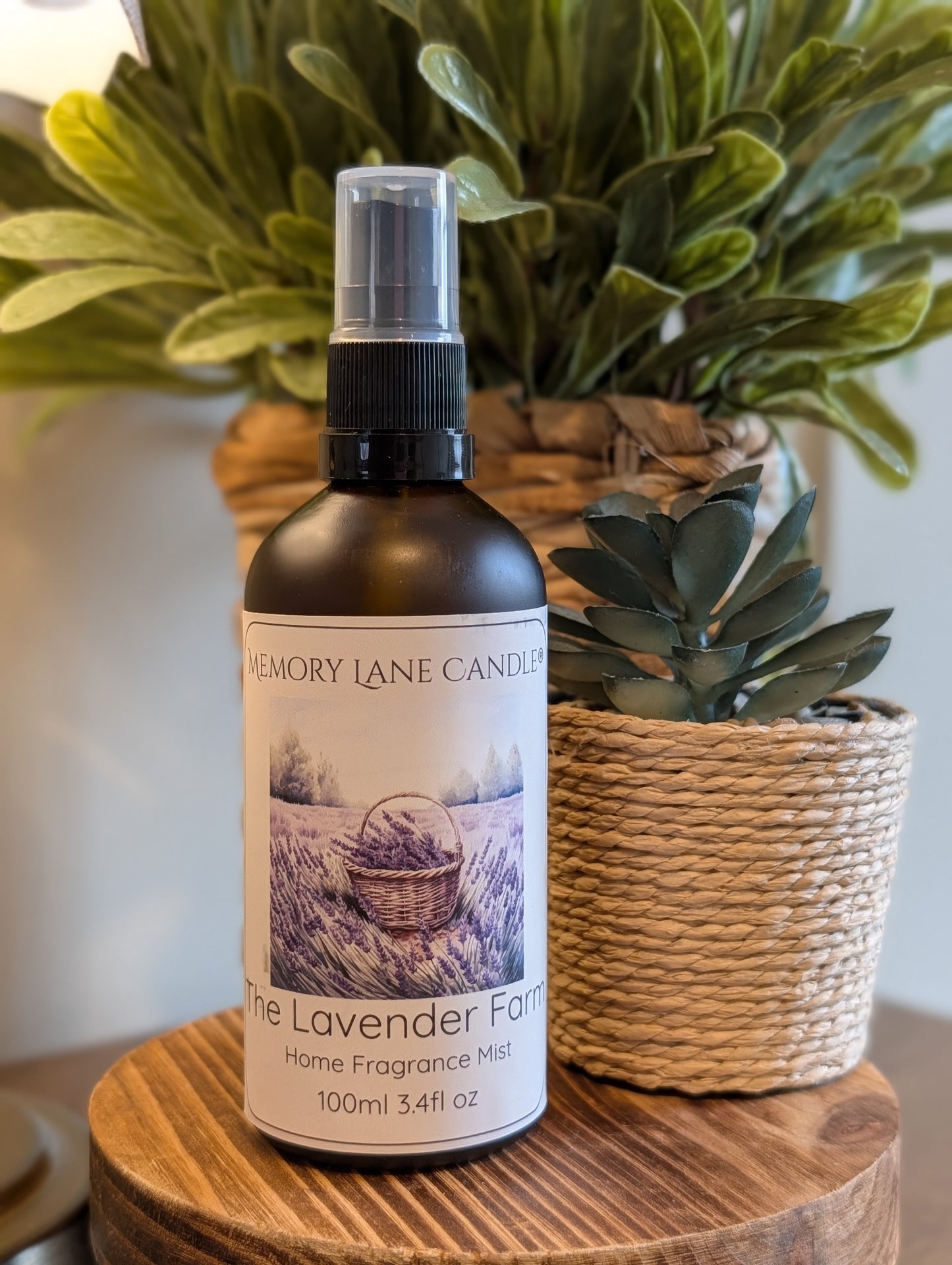 Home fragrance mist bottle labeled 'The Lavender Farm' on a wooden surface with plants in the background.