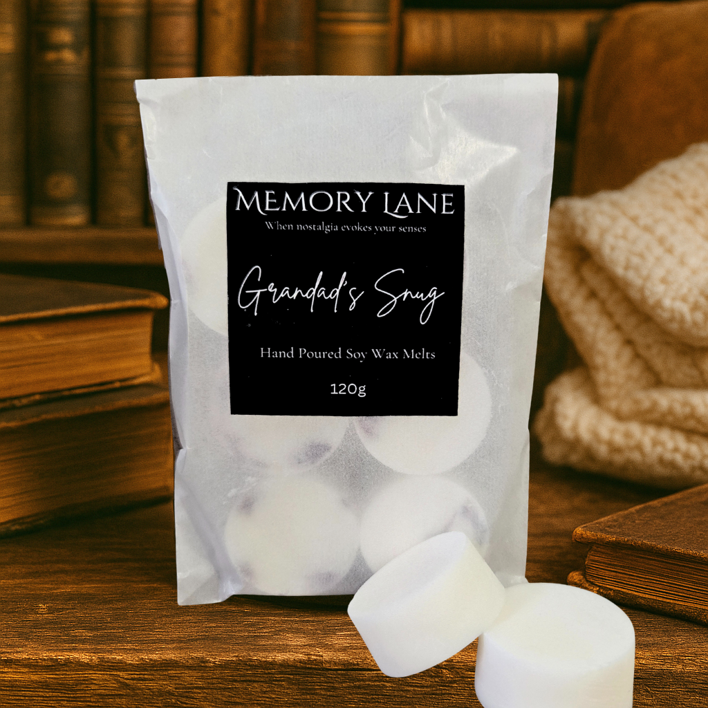 Pack of Memory Lane Grandad's Snug hand poured soy wax melts on a wooden surface with books and a knitted blanket in the background.