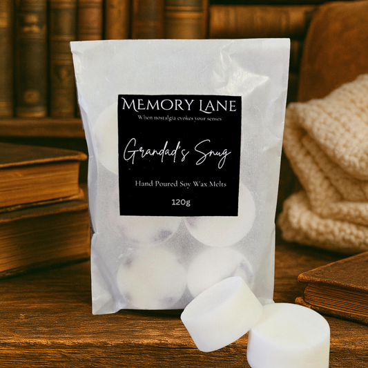 Pack of Memory Lane Grandad's Snug hand poured soy wax melts on a wooden surface with books and a knitted blanket in the background.