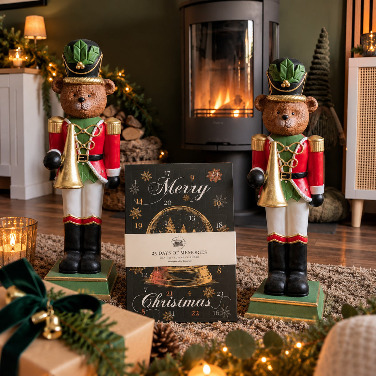 A Christmas-themed advent calendar card reading 'Merry Christmas' and '23 Days of Memories' stands in a cozy living room setting between two large teddy bear nutcracker figurines near a fireplace.