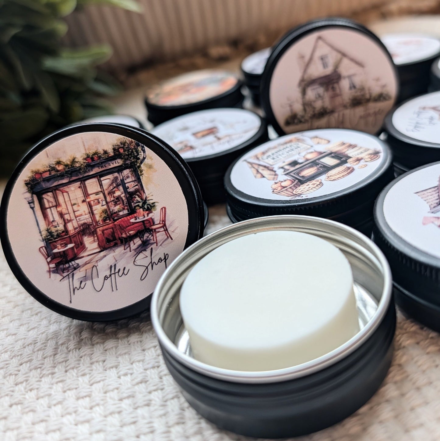 Collection of small containers with lids featuring illustrated designs on a textured surface.