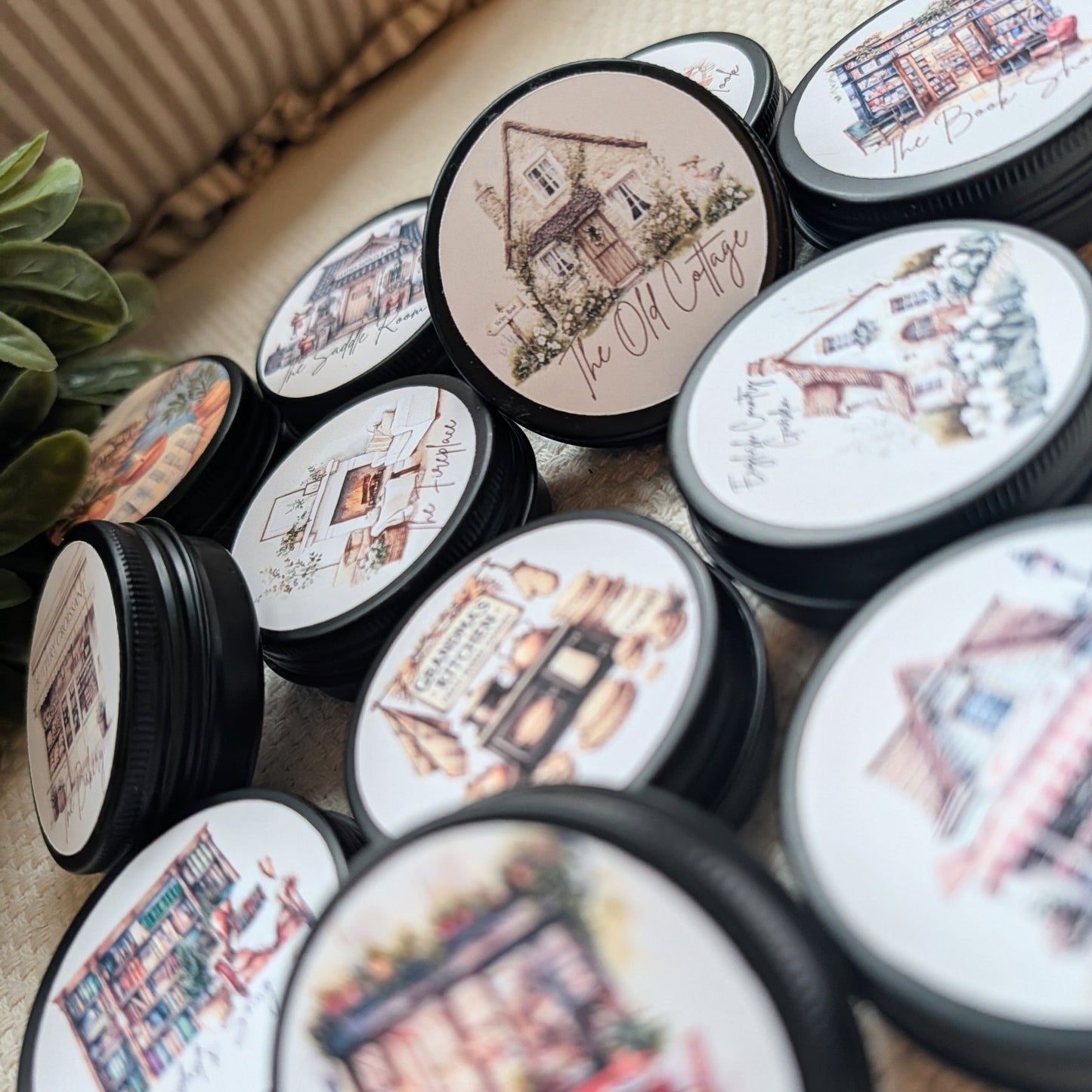 Collection of small containers with decorative lids featuring illustrations and text containing wax melts.