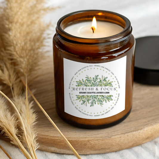 Candle in an amber jar with a label on a wooden surface