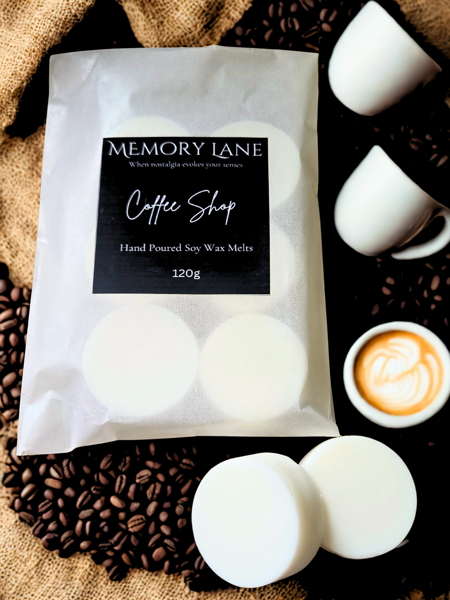 Pack of Memory Lane Coffee Shop wax melts with coffee beans and a cup of coffee in the background.