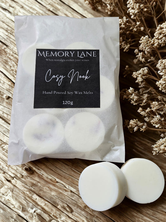 Packaged hand poured soy wax melts from Memory Lane on a wooden surface with dried flowers.